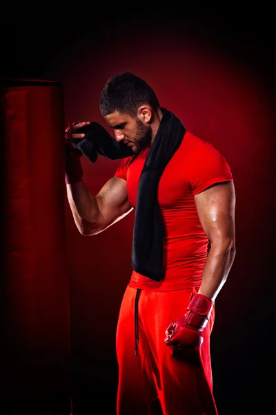 Young man standing by  boxing bag — Stock Photo, Image