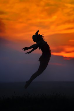 genç kadın yaz akşamında kumsalda atlama
