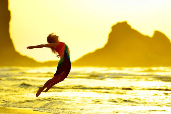 Jonge vrouw op het strand in de zomer zonsondergang licht — Stockfoto