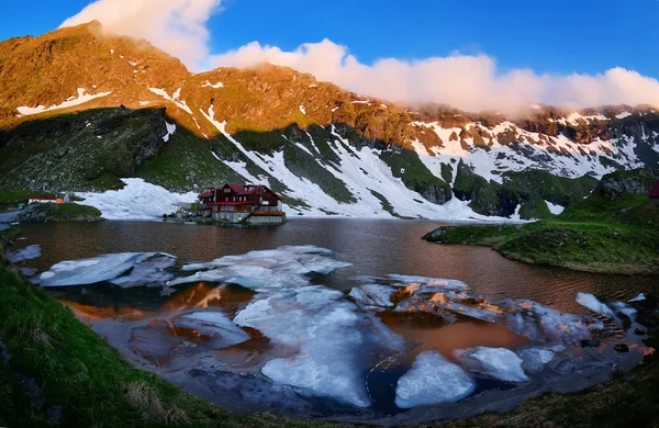 Klidné horské jezero zelené hory a dřevěné chaty — Stock fotografie