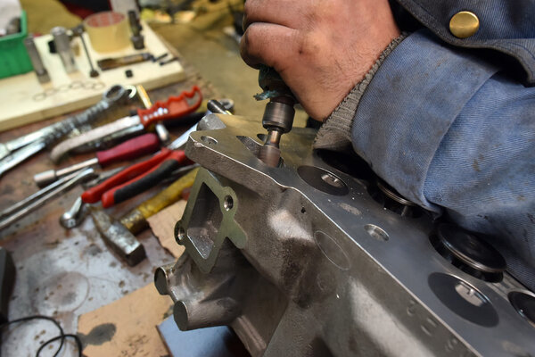 механический ремонт двигателя автомобиля в гараже
