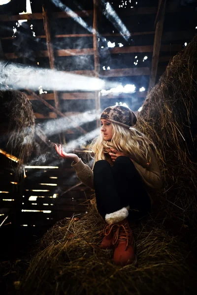 Belle femme relaxante en paille en automne dans une pièce fumée et poussiéreuse — Photo