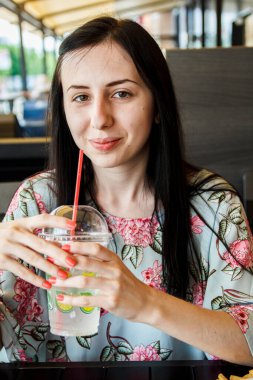 Kız tüpten kokteyl içiyor.