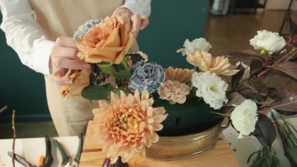 Květinářství v práci v Studio podzimní kytice. Roztomilá mladá dívka dělá módní moderní kytice různých barev. — Stock video
