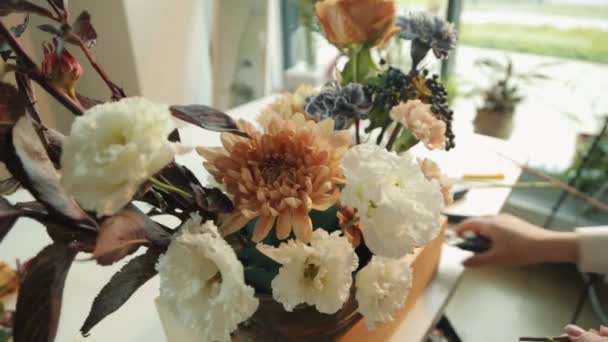 Fleuriste au travail au Studio bouquet d'automne. Mignon jeune fille fait un bouquet moderne à la mode de différentes couleurs. — Video