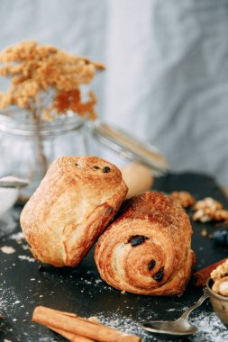 Tahta arka planda çikolata parçalı tatlı. Çikolatayla sarılmış poğaça turtası.