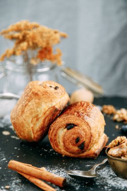 Tahta arka planda çikolata parçalı tatlı. Çikolatayla sarılmış poğaça turtası.