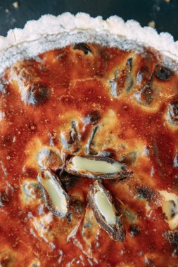 Meyveli kek, karanlık bir masada yakın plan dilimler halinde kesilmiş. Tatlı reçelli ve kurabiyeli pasta..