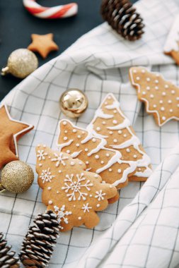Hafif arka planda zencefilli kurabiye ve koni kompozisyonu. Kurabiyeli ve noel ağaçlı yassı bir ev..