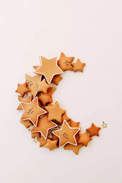 白い背景に月の形をしたクッキーが散乱しています 星の形をしたクリスマスジンジャークッキー — ストック写真