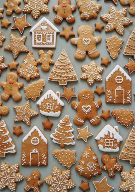 Ev şeklinde kurabiyeler, Noel ağacı, bir insan, kremayla süslenmiş bir yıldız. Kış tatili şablonu, zencefilli çörek seti, desenlerin düzeni..