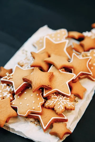 Galletas de jengibre de invierno en forma de estrella en una tabla de madera. Set de galletas navideñas sobre fondo oscuro. — Foto de Stock