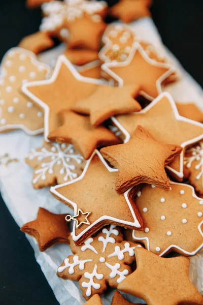 Galletas de jengibre de invierno en forma de estrella en una tabla de madera. Set de galletas navideñas sobre fondo oscuro. — Foto de Stock