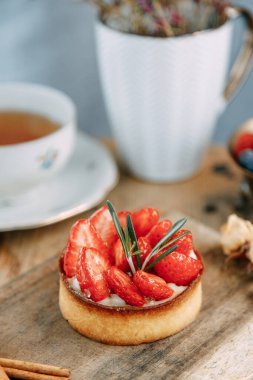 Çilek ve ahududulu mayasız hamurdan yapılmış kek. Ahşap bir masada meyveli tatlı kekler..