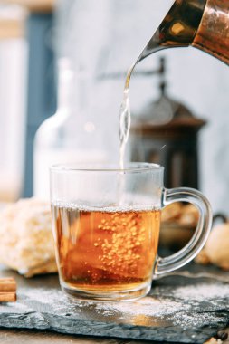 Ev ortamında buharlı bir çay akıntısı. Çay seremonisi. Çaya kaynar su dökülüyor..