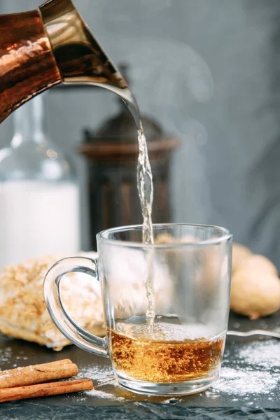 Ev ortamında buharlı bir çay akıntısı. Çay seremonisi. Çaya kaynar su dökülüyor..