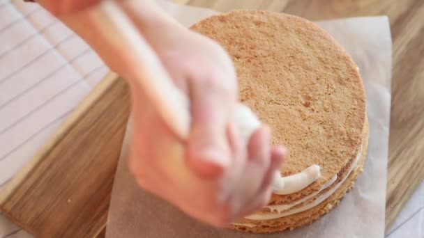 一位女糕点厨师将奶油倒在一个装有糕点袋的饼干上 这是一个特写镜头 一个糕点厨师准备了一个自制的昨天做的蛋糕 — 图库视频影像