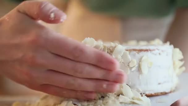 一位女糕点厨师准备了一个蛋糕 并用杏仁片装饰 制作热腾腾的糕点的各个阶段 — 图库视频影像