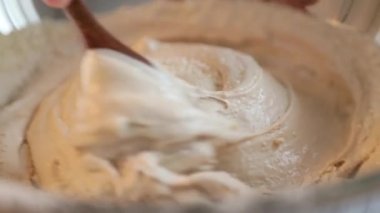 Demir bir kasede hamur yoğurmak. Pasta şefi kız tatlı kek hazırlıyor. 60 fps.