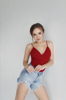 Uzun kahverengi saçlı güzel bir genç kadın. Parlak bir stüdyoda test modelleri, pencereden gelen doğal ışık..