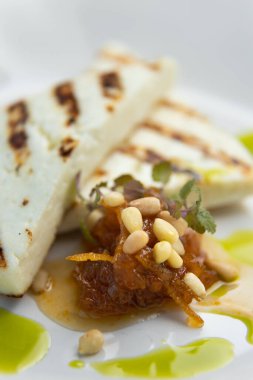 Izgara peyniri yakın plan bir tabakta. Yunan yeşillikleriyle ev yapımı ızgara peynir..