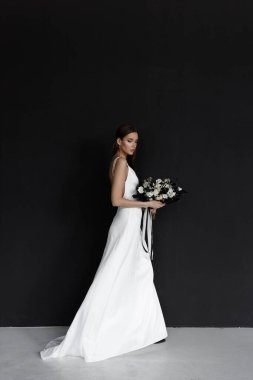 Siyah arka planda beyaz gelinlikli güzel bir kadın. Zarif bir elbise içinde modern moda bir gelin..