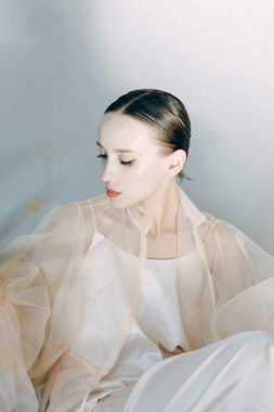 Stüdyoda güzel bir kız poz veriyor, güzel sanatlar tarzında. Uçan elbiseli, şehvetli bir bayanın moda sanat fotoğrafı..