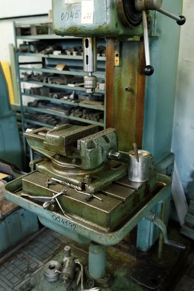 Drilling machine in the old shop. Drilling machine parts and spindle with drills.