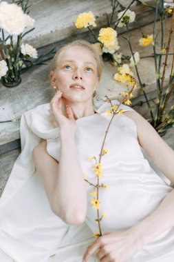 Düğünde son moda sarı çiçekçi. Düğün modası ve gelin konsepti. Taş basamaklarda Avrupa tarzında çekici bir gelin..