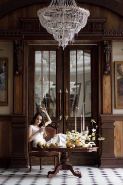 Gelinin koyu renkli, lakonik Avrupa tarzı bir görüntüsü. Beyaz elbiseli, şık, modern bir gelin. Keskin, kavramsal bir imaj..