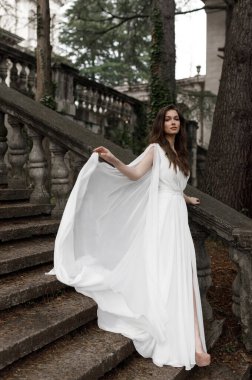 Gelin, bahçeye bakan villanın merdivenlerinden çıkar. Avrupa tarzında eski bir villada düğün, trendler 2021.