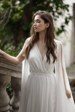 Gelin, bahçeye bakan villanın merdivenlerinden çıkar. Avrupa tarzında eski bir villada düğün, trendler 2021.