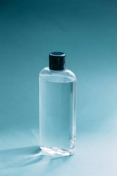 A jar of cosmetics, eco-friendly cosmetics. Transparent glass bottle of cosmetic perfume on a blue background.