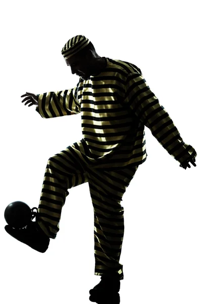 Muž vězeň trestní hrát fotbal s řetězci míč silueta — Stock fotografie