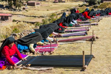 women weaving in the peruvian Andes at Puno Peru clipart