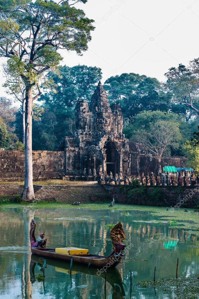 woman boat moat south gate bridge Angkor Thom Cambodia 