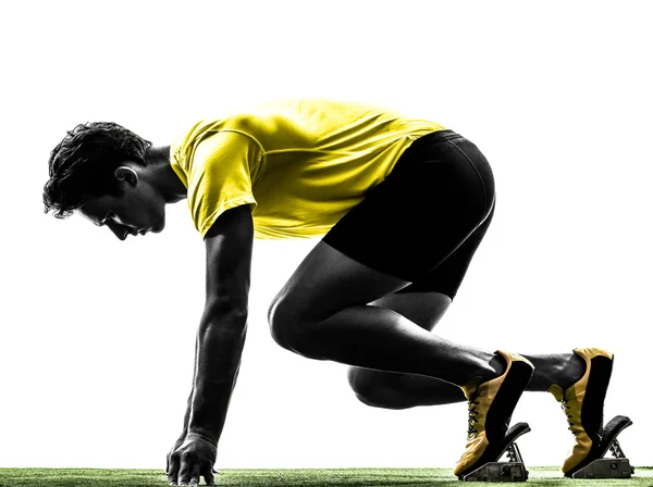 Young man sprinter runner in starting blocks silhouette — Stock Photo, Image