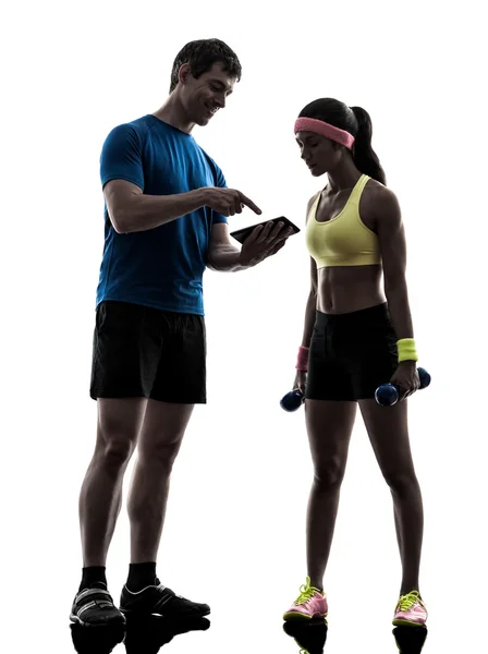 Woman exercising fitness  man coach using digital tablet  silhou — Stock Photo, Image