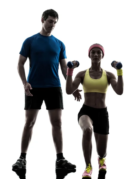 Mulher exercitando fitness musculação com homem treinador silhueta — Fotografia de Stock