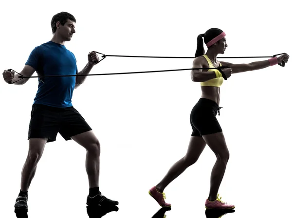 Mulher exercitando resistência fitness elástico com homem treinador — Fotografia de Stock