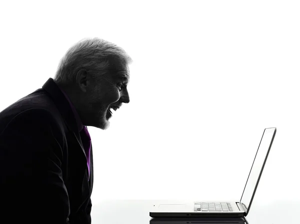 Homem de negócios sênior sorrindo computador portátil silhueta — Fotografia de Stock