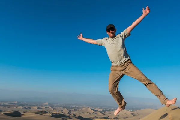 Man jumping in the desert of the peruvian coast at Ica Peru — Stock Photo, Image