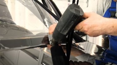 Modern lüks arabalardaki boya korumalı film tesisatını kapatın. PPF, boya yüzeyini taştan, böcek sıçramasından ve aşınmadan korumak için araba boyasını saran poliüretan bir filmdir..