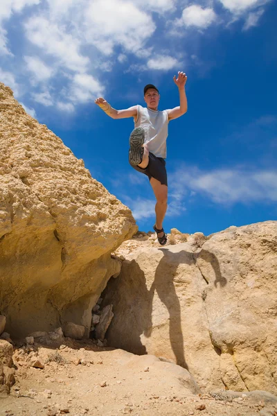Parkour man jumping high over rocky mountains — Stock Photo, Image