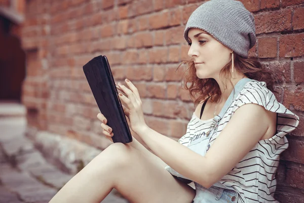 Hipster young girl works on the tablet on the internet — Stock Photo, Image