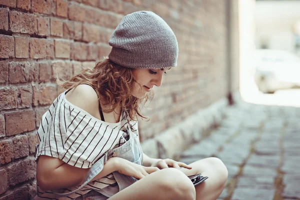 Beautiful hipster girl works on the tablet on the internet — Stock Photo, Image
