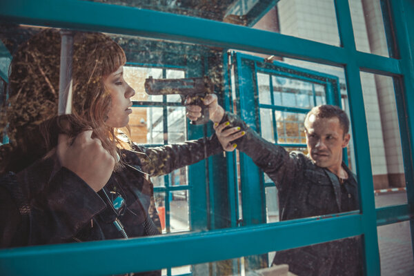 Robber with a gun threatening young beautiful girl