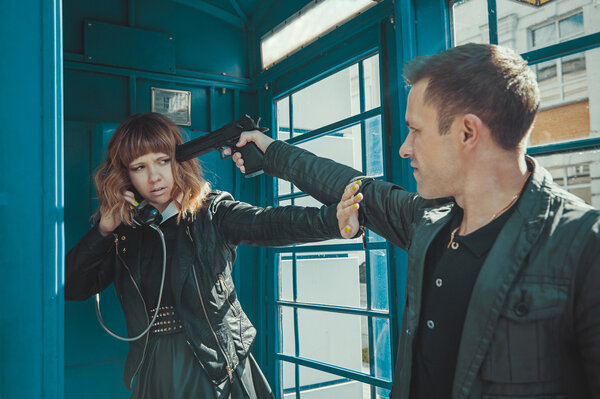 Robber with a gun threatening young beautiful girl