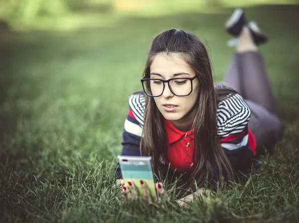 Menina bonita hipster usando telefone inteligente Fotos De Bancos De Imagens Sem Royalties