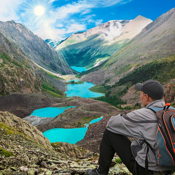 Caminante con mochila sentado en la cima de la montaña — Foto de Stock